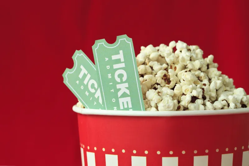 popcorn bag and movie ticket on red background