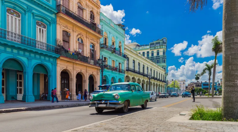 cityscape with american green vintage car on the main street in havana city cuba - serie cuba reportage