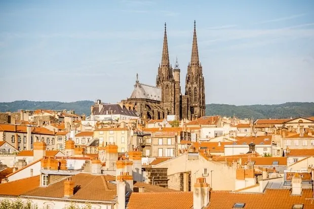 morning aerial cityscape view on clermont-ferrand city with beautiful cathedral and mountains on the background in central france