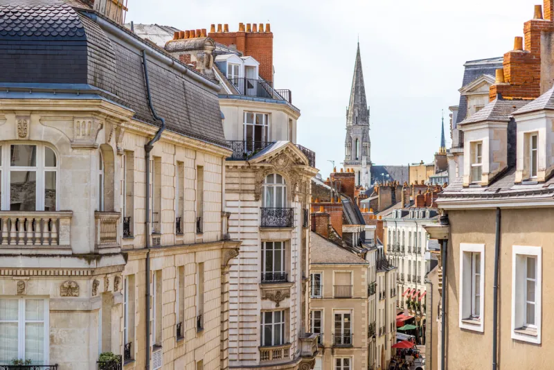 street view on the beautiful residential buildings andchurch tower in nantes city during the sunny day in france