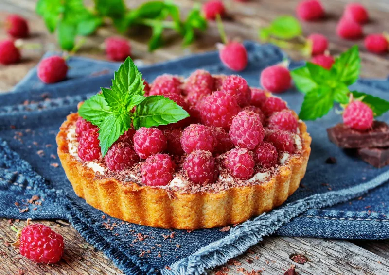 delicious raspberry tart with fresh raspberries and mint on a beautiful background