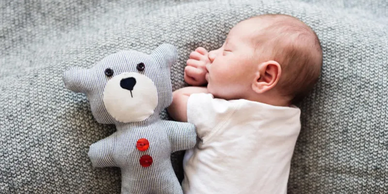 mignon petit garçon nouveau-né couché sur le lit avec son ours en peluche, dormir, gros plan