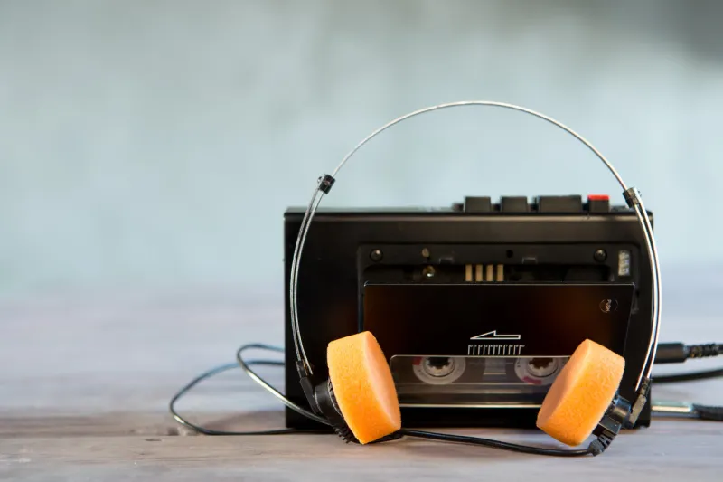 old portable cassette player and headphones on a abstract background vintage advertisement style