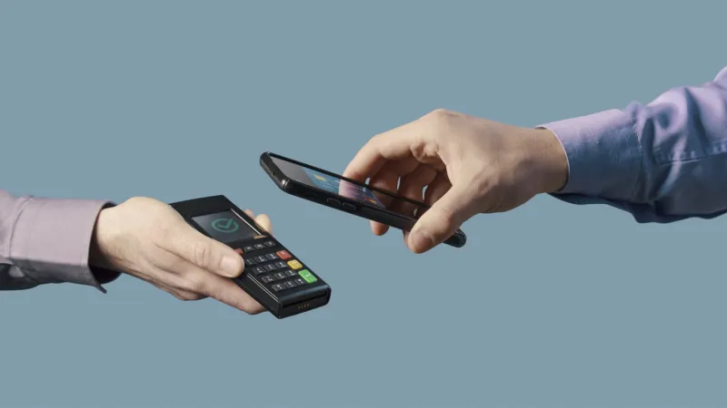 man making a contactless transaction using his smartphone, digital payments concept