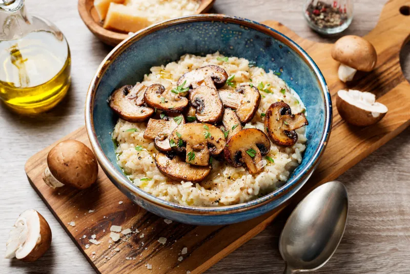 risotto with brown champignon mushrooms on wooden background