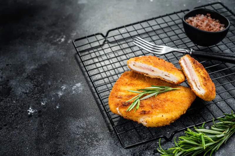schnitzel cordon bleu fillet cutlet with ham and cheese black background top view copy space