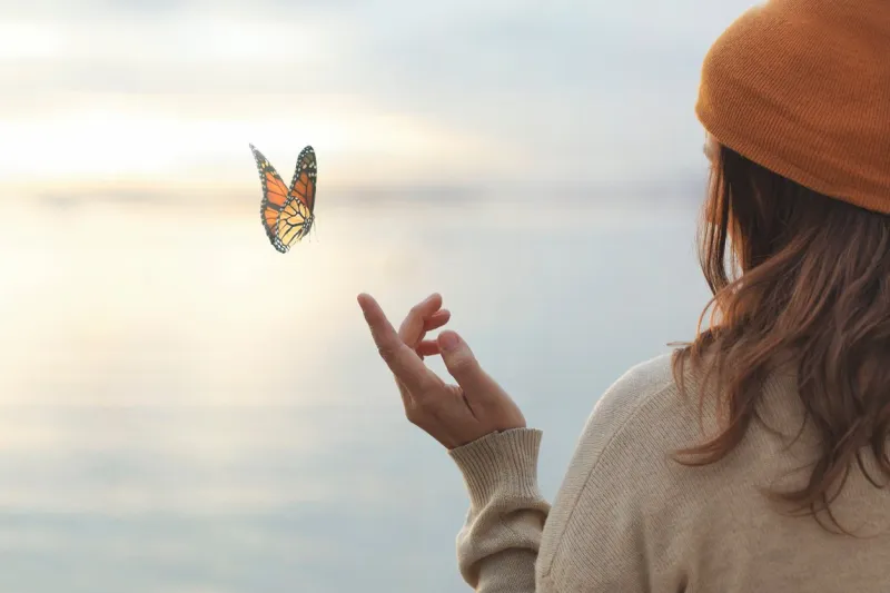 colorful butterfly is laying on a woman's hand