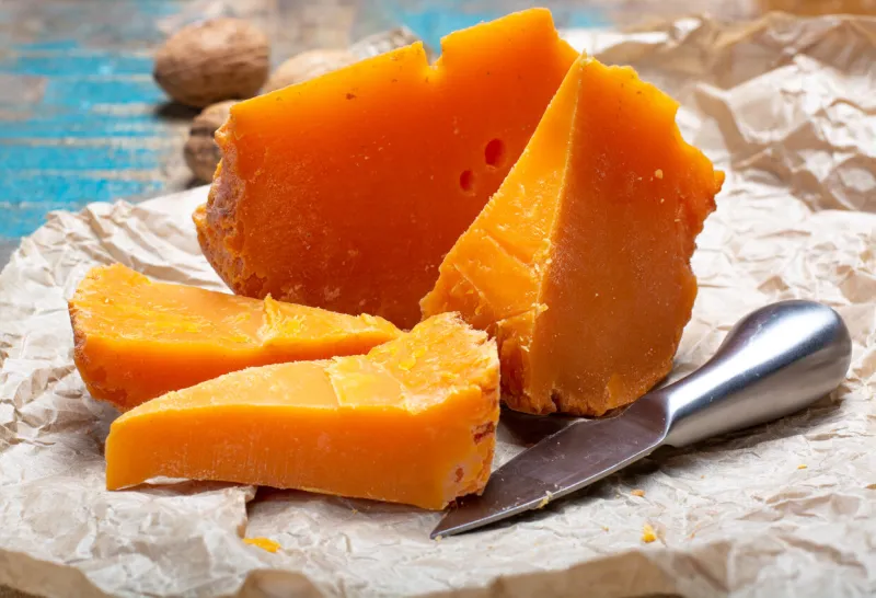 pieces of native french aged cheese mimolette, produced in lille with greyish curst made by special cheese mites close up