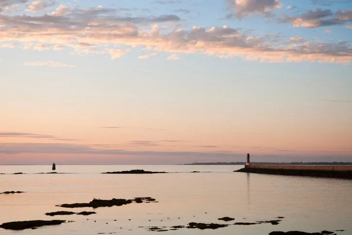 beautiful colored sunset on le croisic jetty with lighthouse « le trehic » in brittany - france