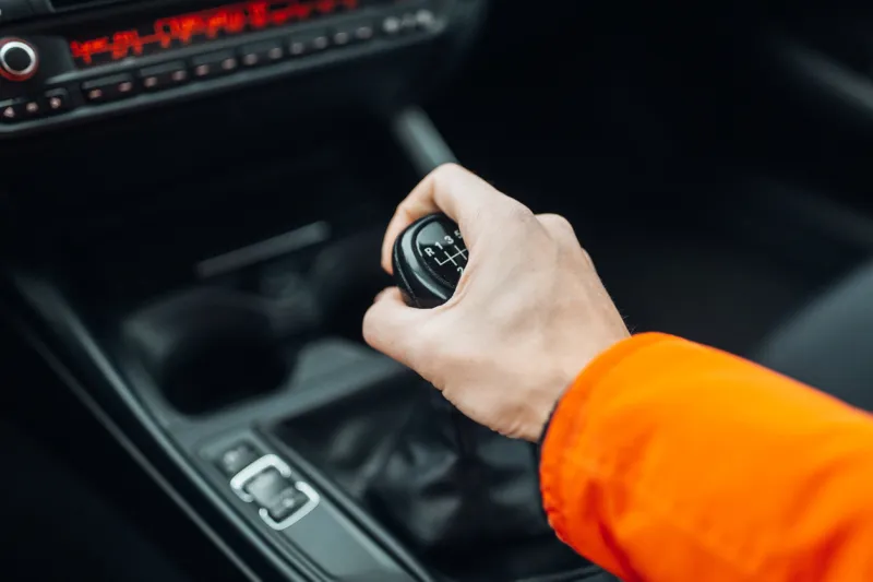 man's hand switches manual transmission closeup