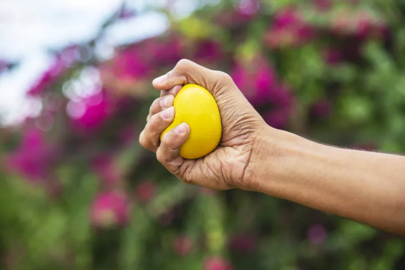 hand squeezing stress ball in nature