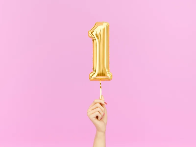 one year birthday female hand holding number 1 foil balloon one-year anniversary background 3d rendering
