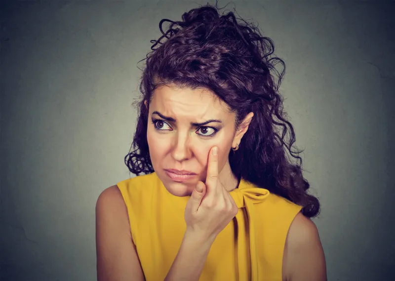 woman pulling down eyelid checking her eye looking in morrow feels unwell has black circles