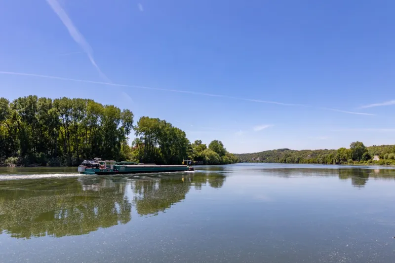 barge moving on seine river near la roche-guyon, val d'oise, france
