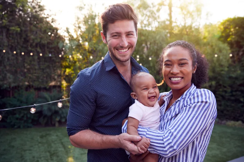 portrait of family with baby son at home outdoors in garden