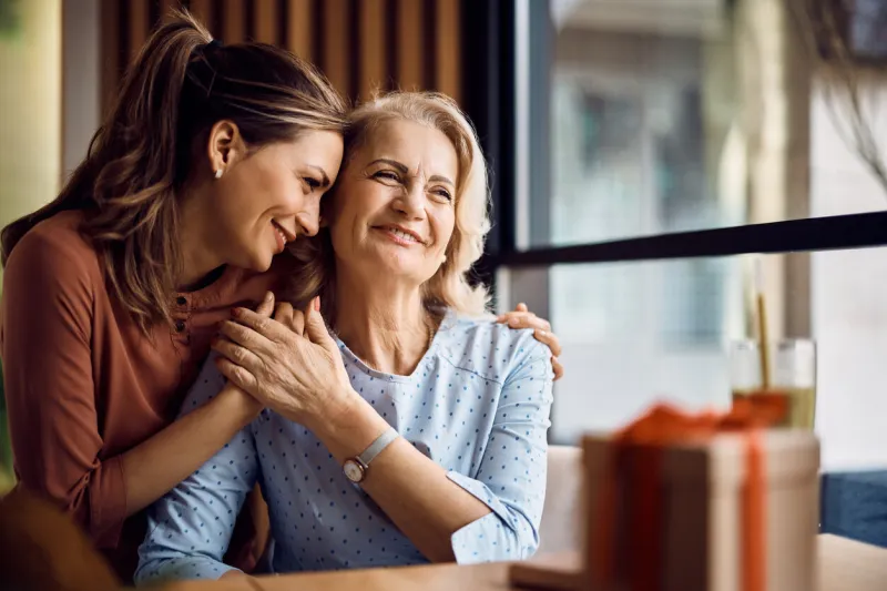 happy senior woman enjoying in daughter's affection on mother's day