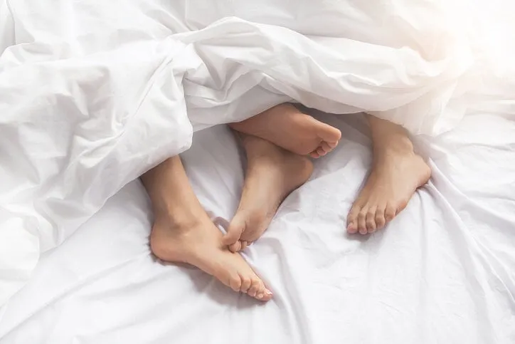 young couple man and woman intimate relationship on bed feet