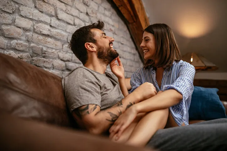 cropped shot of a happy young couple cuddling in the living room