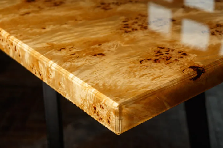 table top for a table made of poplar burl wood and transparent epoxy resin the resin is varnished and polished, the wood is saturated with tung oil