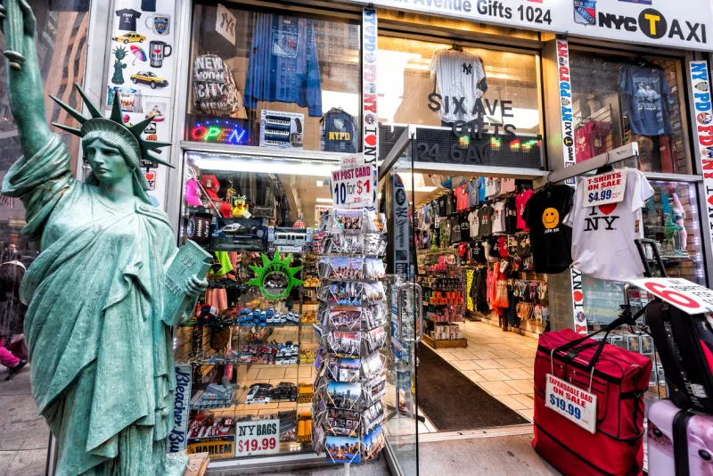 new york city, usa - april 6, 2018  manhattan nyc midtown herald square, 6th avenue road, sign for souvenir gift shop, statue of liberty replica, many postcards