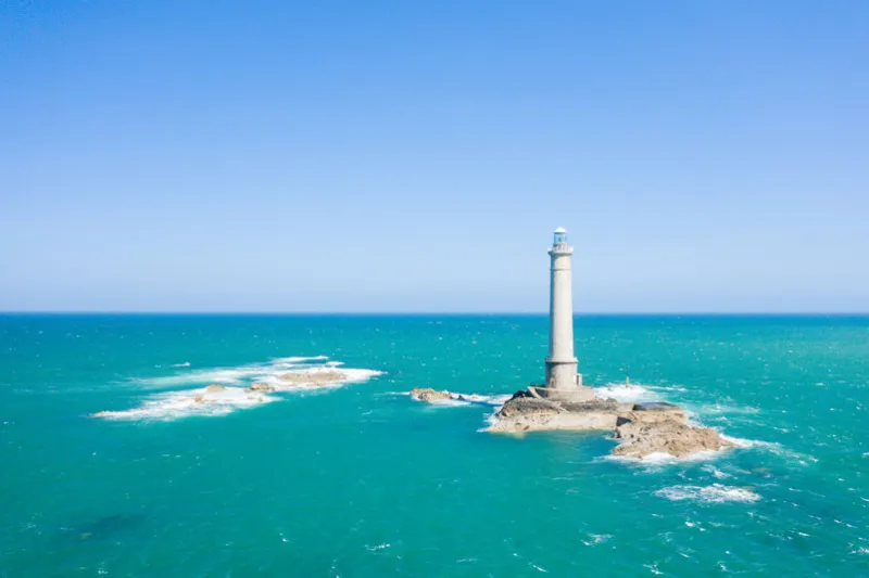this landscape photo was taken in europe, france, normandy, the english channel, in the spring we see the lighthouse of cap de la hague and the waves of the english channel, under the sun
