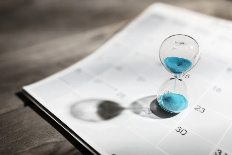 hour glass on calendar concept for time slipping away for important appointment date, schedule and deadline