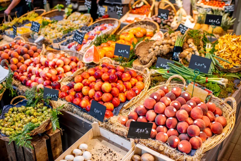 variety of beautifully organized fruits and vegetables on the counter of the market place