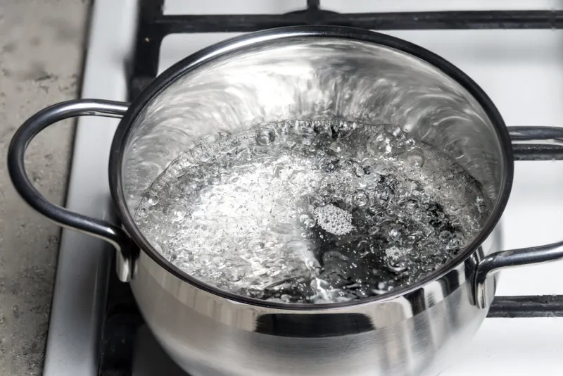 water boils in a stainless steel pan on a gas stove boiling water surface
