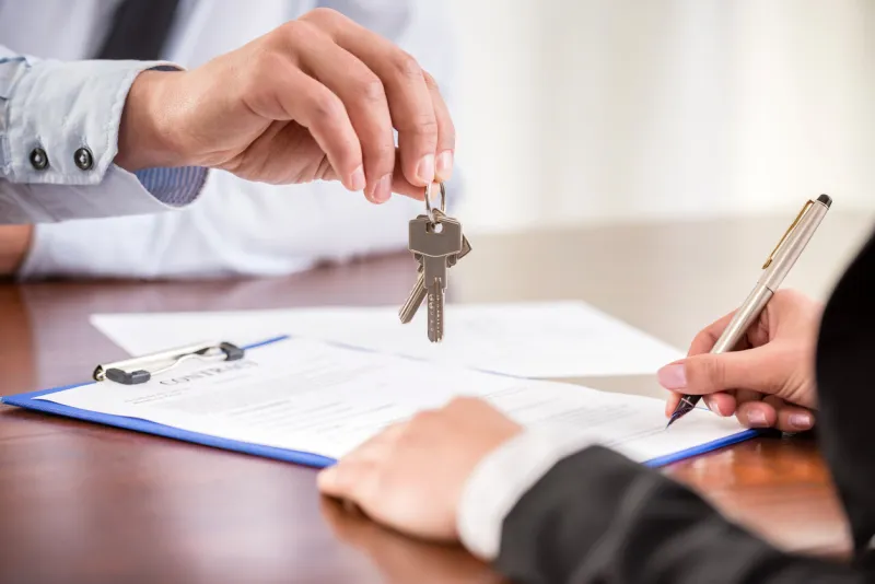 young woman is signing financial contract with male realtor close-up