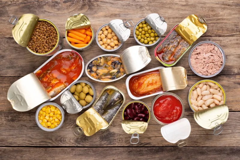 canned food on wooden background, top view