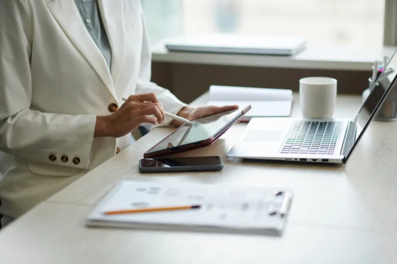 close-up image of businesswoman checking documents and reports on tablet computer