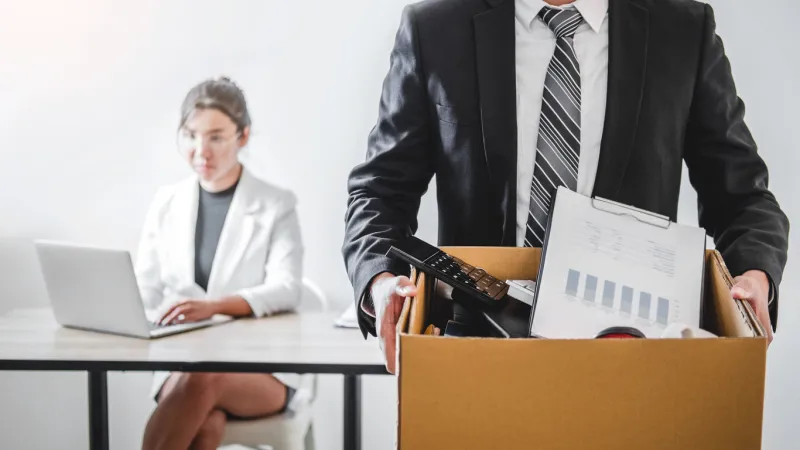 business man stressing with resignation letter for quit a job packing the box and leaving the office , resignation concept