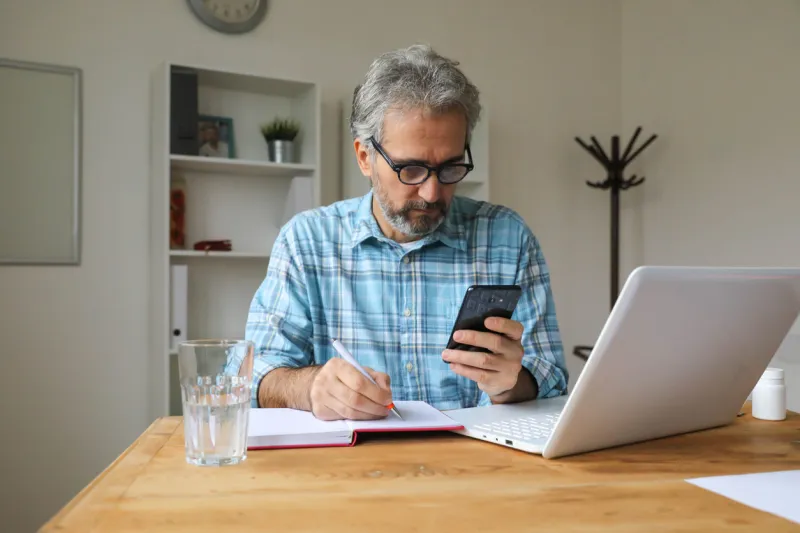 gray hair man video chatting with doctor telemedicine check up from home over the internet checks possible symptoms, using online video chat