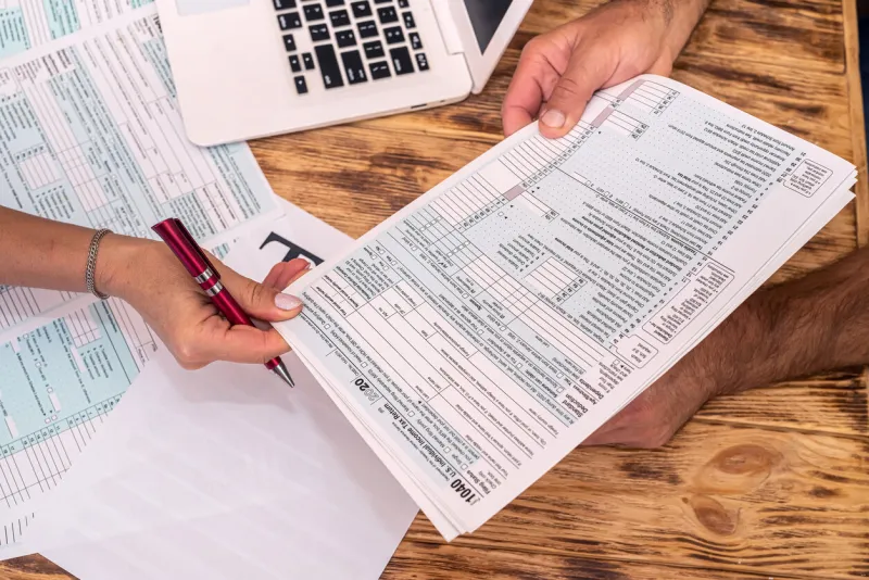 two employees at work fill out tax forms 1040 at the office desk the concept of tax forms