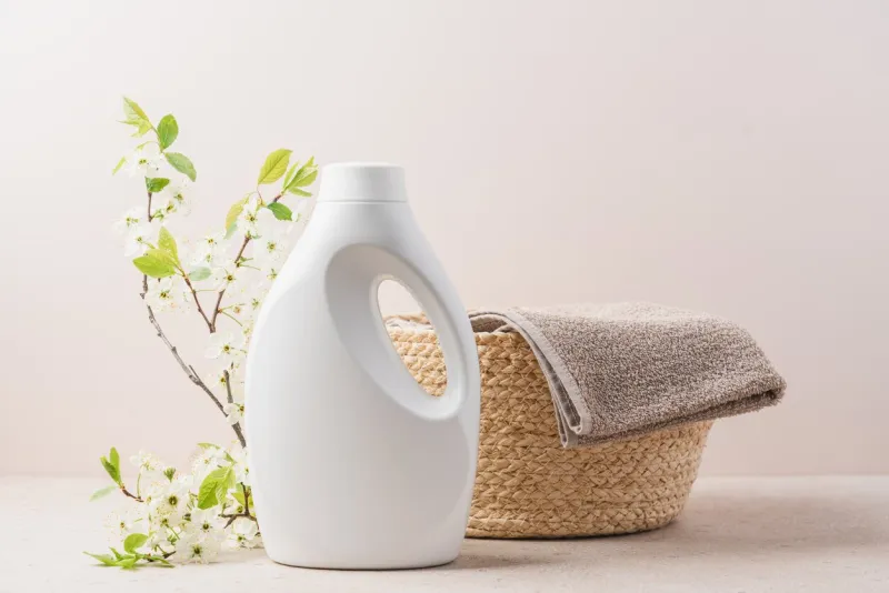 eco-friendly washing white bottle and clean towel in wicker basket