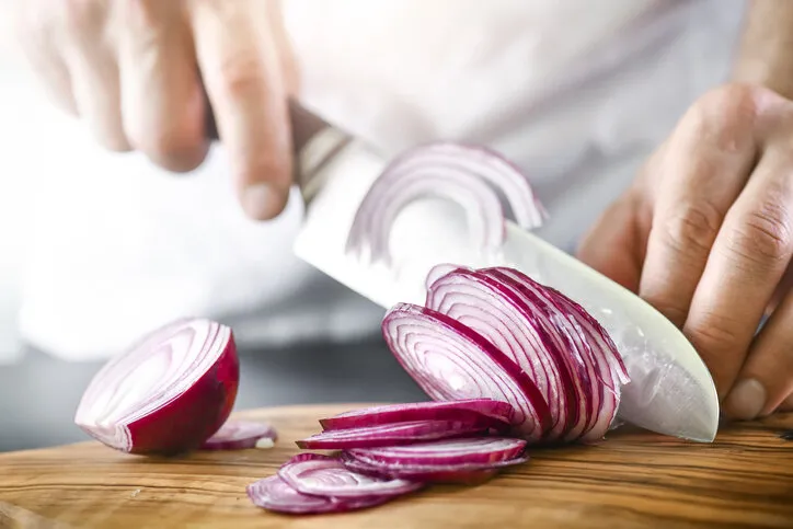 man hands cutting red fresh onion with knife