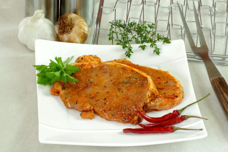 côte de porc marinée cru sur une planche