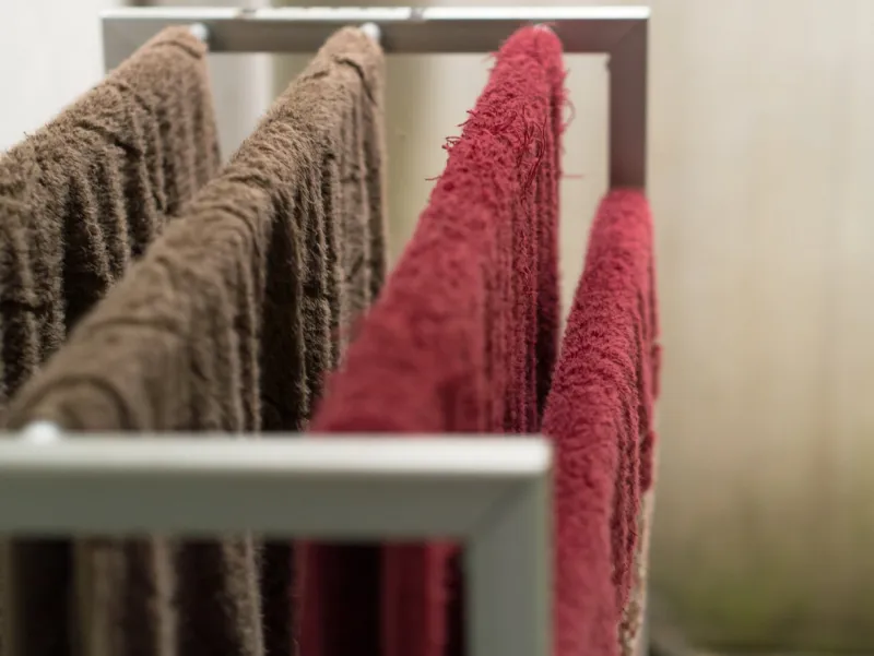 red and brown towels hanging on a rail to dry after being used on bathing routine