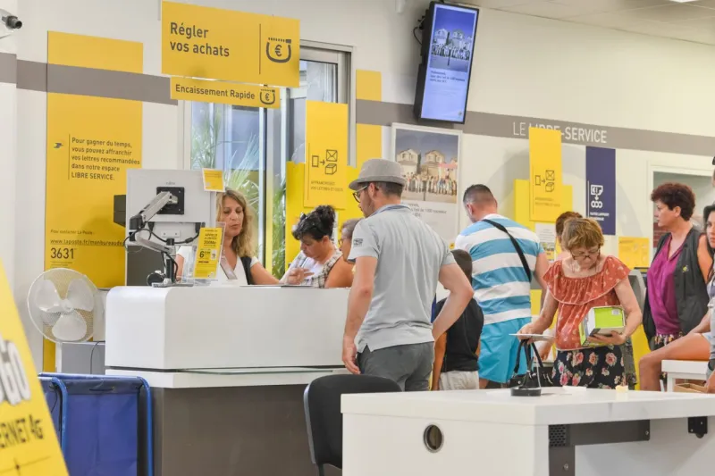 cap d'agde, france - july 27, 2016  people stand in a queue for post office services sending parcelcardboard boxes