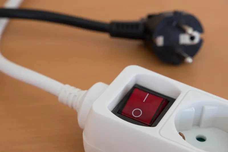 a plug out of a multiple socket with a lamp which is switched off