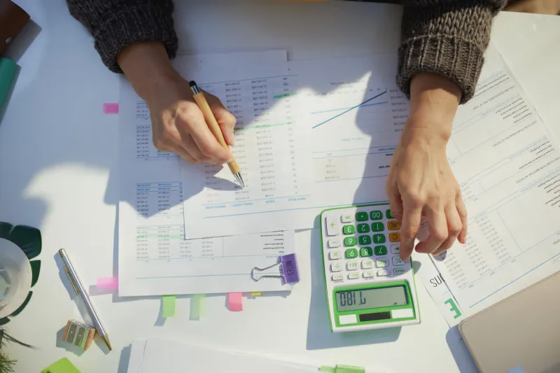 accountant woman with calculator and documents working in office