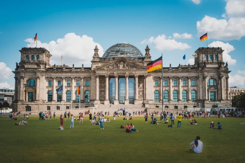 berlin, germany - august, 2019  many people on meadow in front of the reichstag building (german bundestag), a famous landmark on a sunny, summer day in berlin, germany