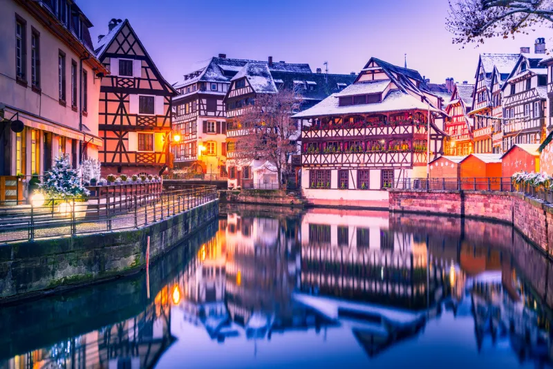 strasbourg, alsace traditional alsatian half-timbered houses with mirror reflections in petite france during twilight decorated christmas season