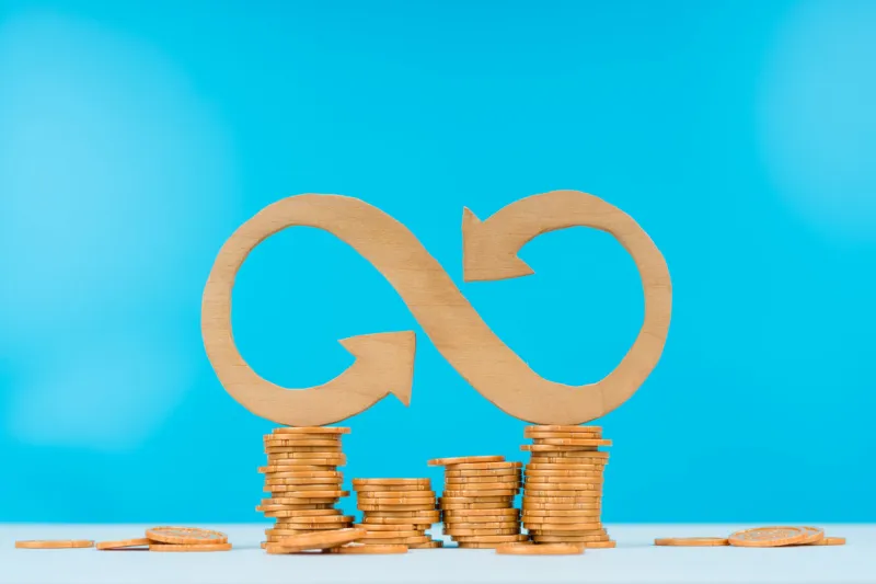 infinity sign on gold coins on a white table and blue background business concept idea money, office teamwork, cooperation, partnership banking, endless earnings, credit