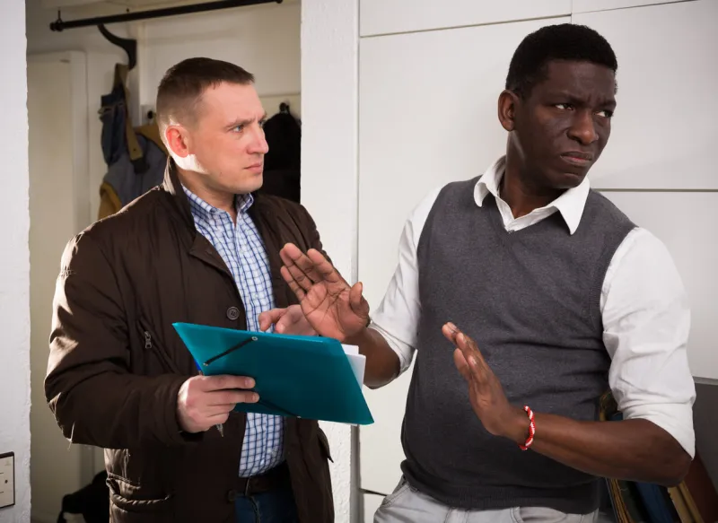 upset african american man refusing to pay debt to debt collector who visited him at home