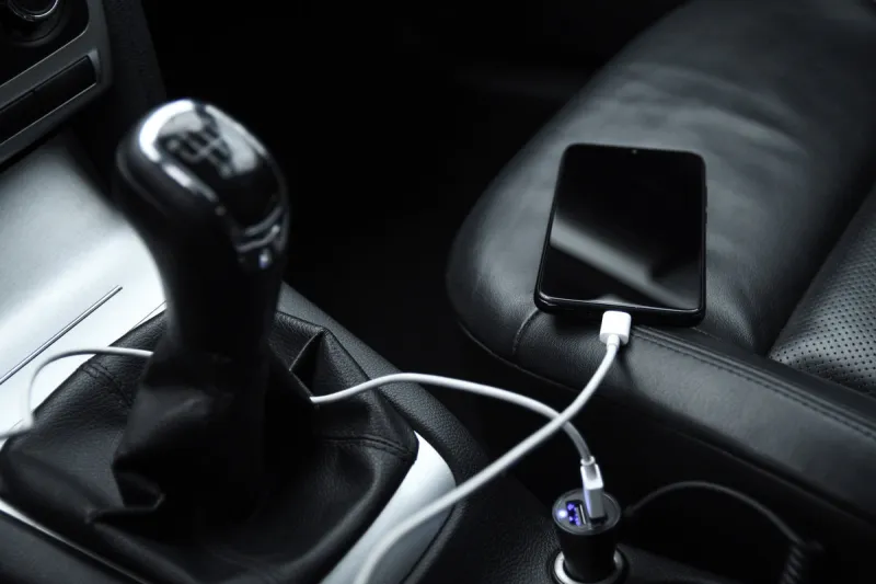 mobile phone, smartphone charge battery, charging in the car plug close up