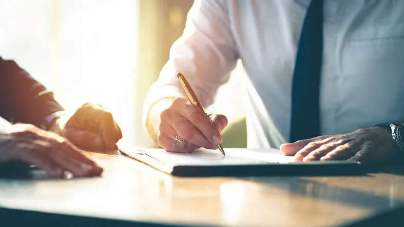 closeup businessman signing a contract investment professional document agreement on the table with pen