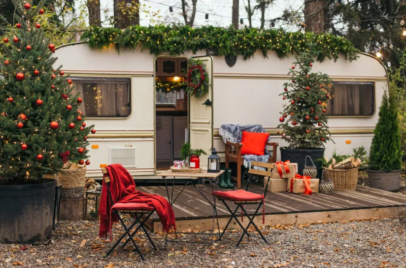 caravan mobile home with terrace, mobile home decorated with christmas decor festive atmosphere - lights, red blankets, christmas trees waiting for the snow caravan camping mobile home trailer