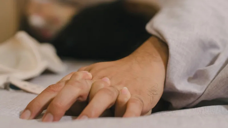 hands of couple lovers having sex on a bed in morning with lust and love, close up hands of a couple having sex on a bed