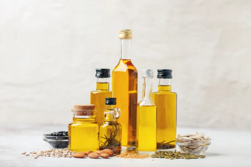 various vegetable and nut oil in bottles on a bright background